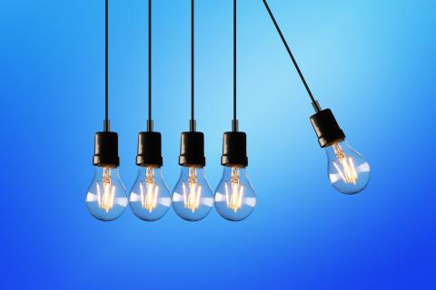 Five light bulbs hanging with one moving